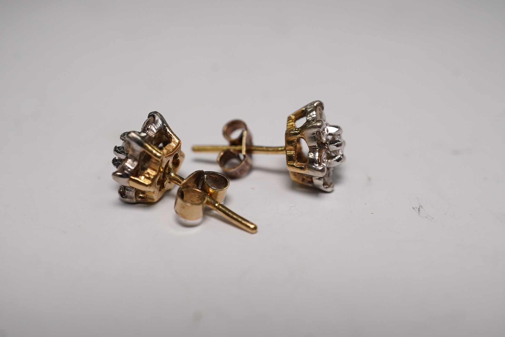 A white metal, diamond and ruby set pendant, 26mm and a pair of 9ct and diamond cluster set ear studs, gross weight 6.1 grams. Condition - fair to good